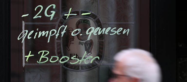 Am Fenster einer Kneipe ist der Hinweis "-2G + - geimpft o. genesen + Booster" aufgemalt. (Foto: dpa Bildfunk, picture alliance/dpa | Arne Dedert)
