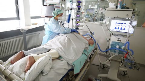 Ärzte und Pfleger untersuchen einen Patienten auf der Covid-19 Intensivstation (Foto: dpa Bildfunk, picture alliance/dpa/dpa-Zentralbild | Bodo Schackow)