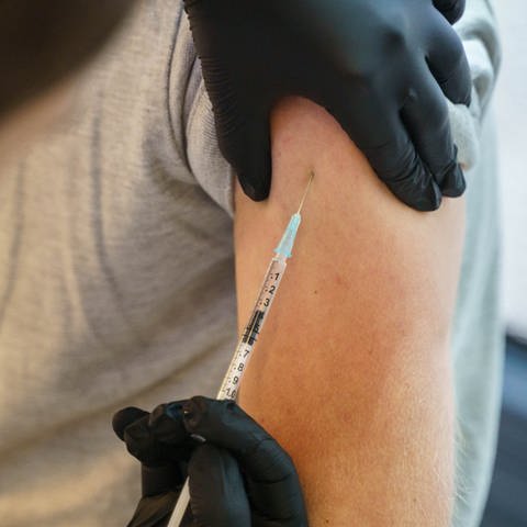 Ein junger Mann bekommt in einem Impfbus eine Corona-Impfung (Foto: dpa Bildfunk, picture alliance/dpa | Frank Rumpenhorst; Symbolbild)
