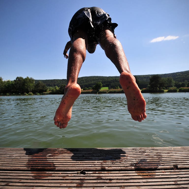 Ein junger Mann springt am Montag mit Kopfsprung in einen Badesee  (Foto: dpa Bildfunk, picture alliance / dpa | Jan-Philipp Strobel)