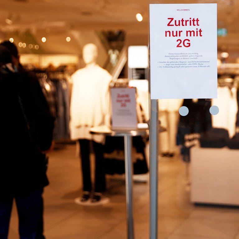Ein Schild am Eingang eines Geschäftes weist auf die 2G-Regel hin.  (Foto: dpa Bildfunk, dpa | Carsten Koall)