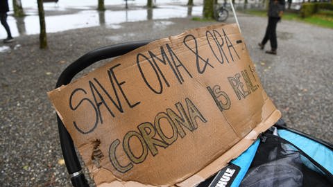 Konstanz: Auf einem Kinderwegen steht ein Schild mit der Aufschrift: «Safe Oma und Opa, Corona ist real».  (Foto: dpa Bildfunk, picture alliance/Felix Kästle/dpa)