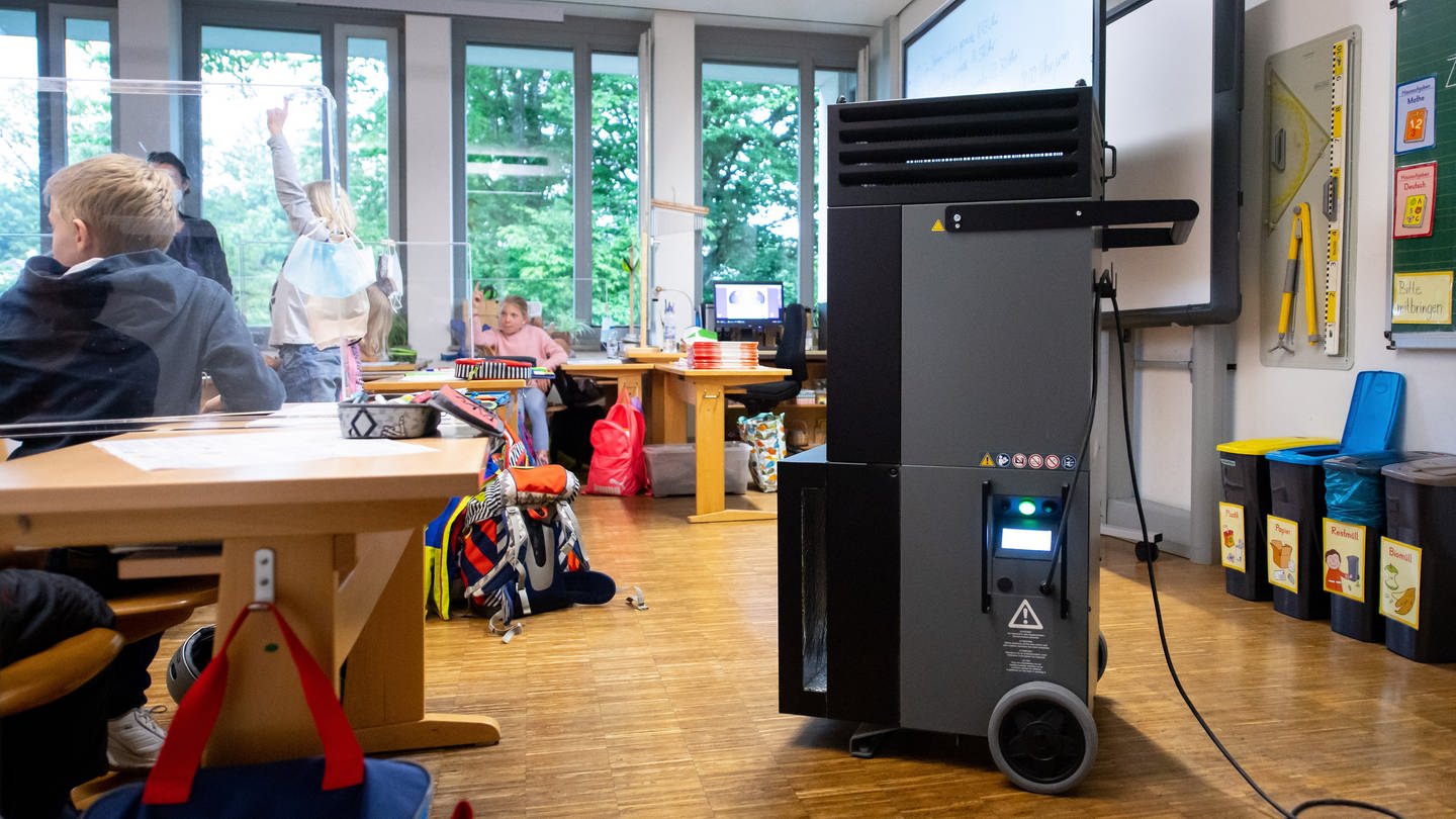 Ein Luftfiltergerät steht in einem Klassenraum in einer Grundschule.