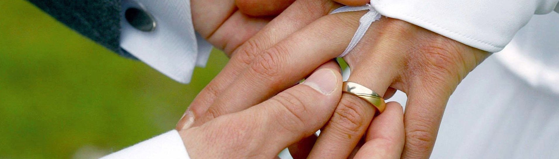 Bei der Trauung streift der Bräutigam der Braut einen Ehering über den Ringfinger (Foto: dpa Bildfunk, picture alliance/dpa/dpa-Zentralbild | Andreas Lander)