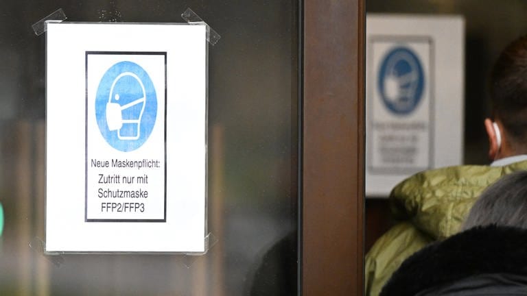 Ein Hinweisschild zum Tragen von Schutzmasken hängt an einer Eingangstür zu einer Gaststätte. (Foto: dpa Bildfunk, picture alliance/dpa | Bernd Weißbrod)