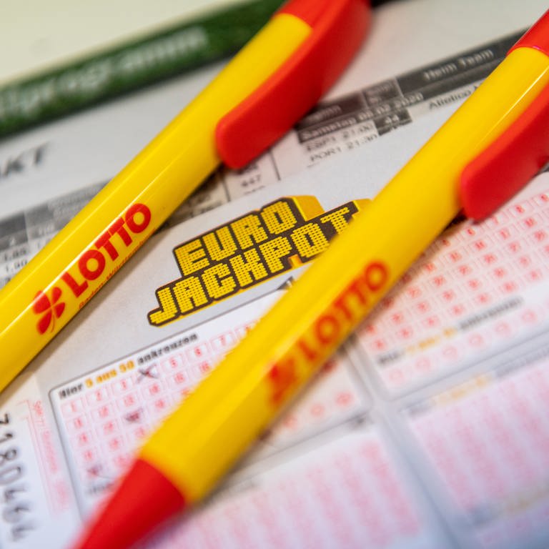 Ein Los für den Eurojackpot und ein Kugelschreiber liegen in einer Lotto-Annahmestelle. (Symbolbild)