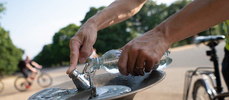 Ein Mann füllt im Park Kensington Gardens an einem Trinkbrunnen seine Wasserflasche auf.  (Foto: dpa Bildfunk, picture alliance/dpa | Sebastian Gollnow)