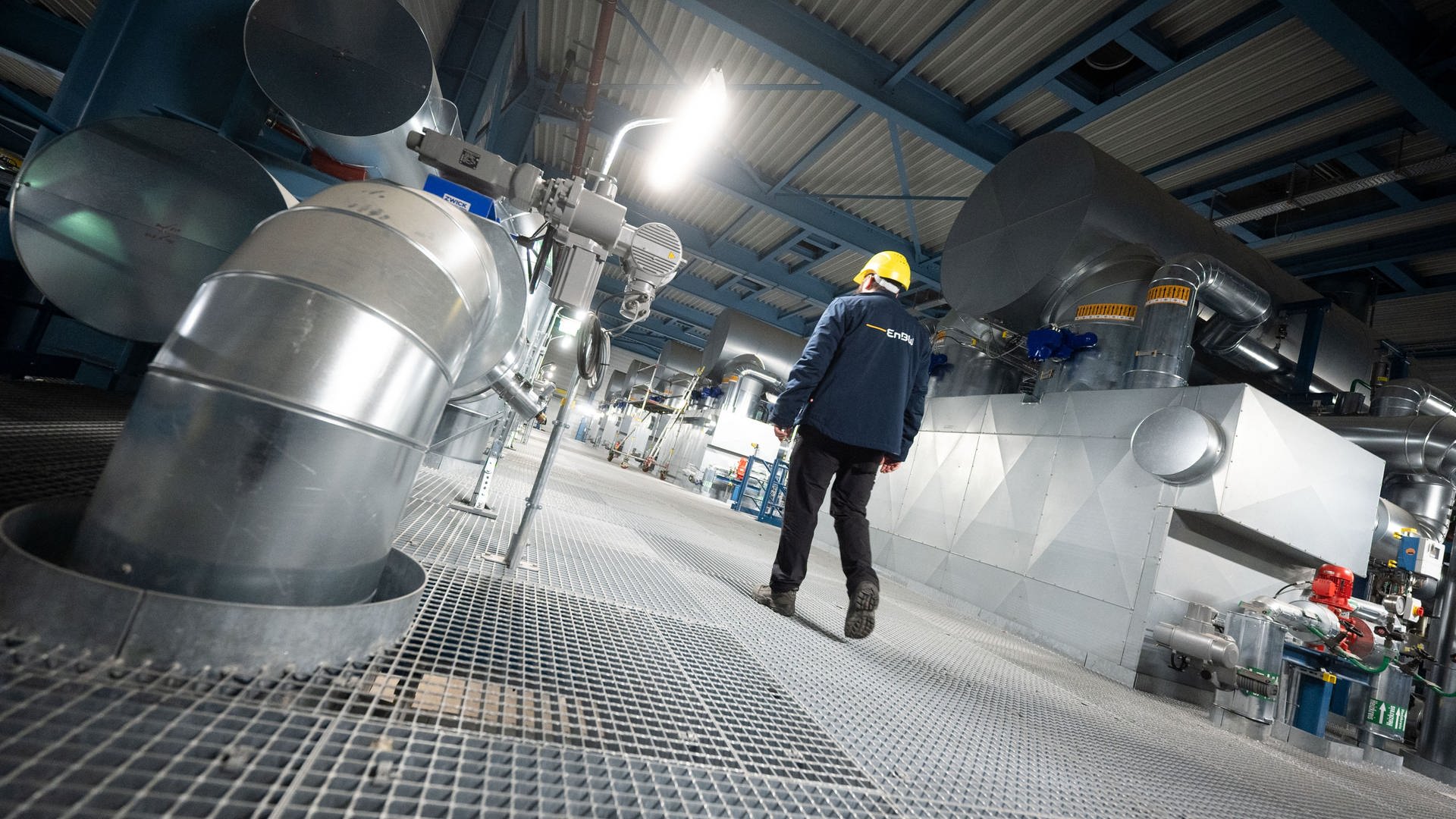 Ein Mitarbeiter des Energiekonzerns EnBW geht an Anlagen des Heizkraftwerk 3 Stuttgart-Gaisburg vorbei, rechts ist ein Gaskessel zur Warmwasserbereitung zu sehen. (Foto: dpa Bildfunk, picture alliance/dpa | Marijan Murat)