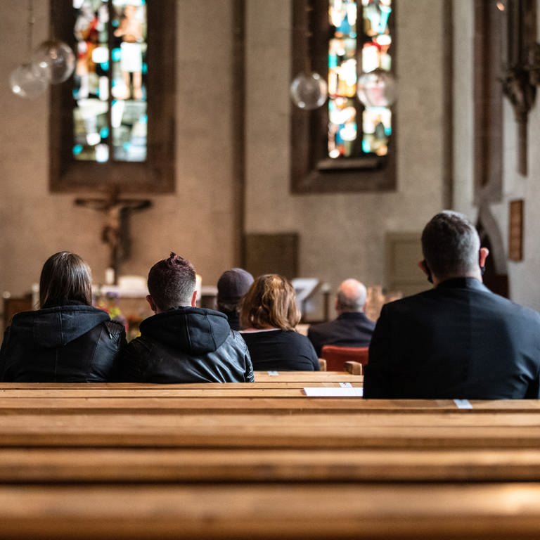 Menschen sitzen bei dem Gottesdienst in den Kirchenbänken der Leonhardskirche in Stuttgart. (Foto: dpa Bildfunk, picture alliance/dpa | Christoph Schmidt)