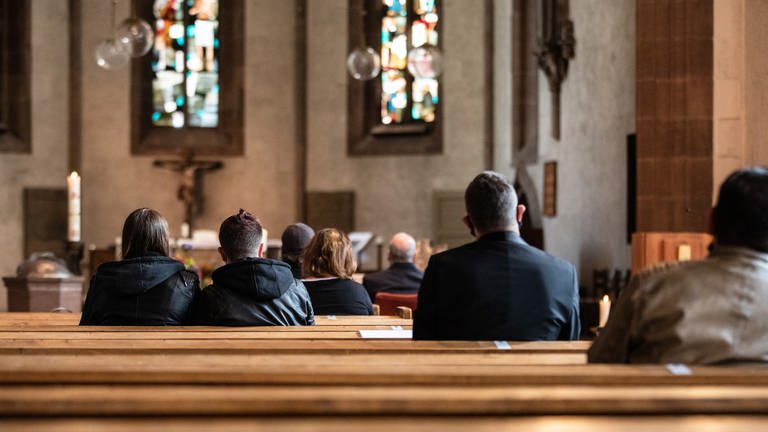 Menschen sitzen bei dem Gottesdienst in den Kirchenbänken der Leonhardskirche in Stuttgart. (Foto: dpa Bildfunk, picture alliance/dpa | Christoph Schmidt)