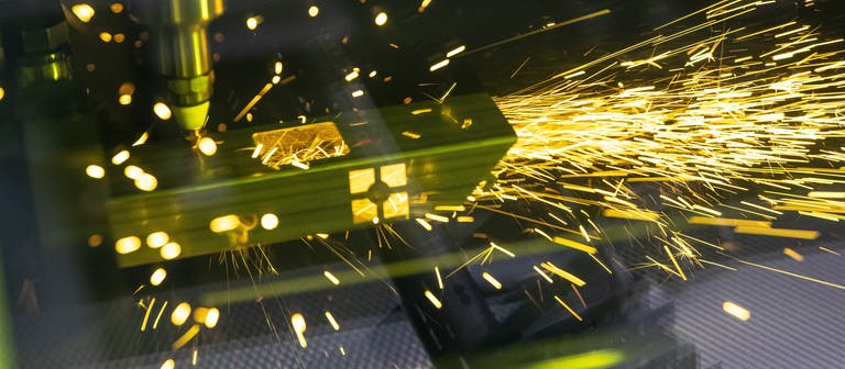Ein Laser schneidet ein Metallteil (Foto: dpa Bildfunk, Picture Alliance)