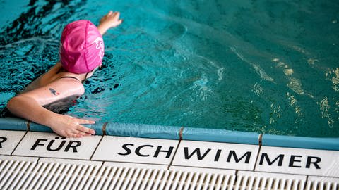 Ein Kind schwimmt in einem Schwimmbad. Auf den Fliesen steht die Aufschrift "für Schwimmer". (Foto: dpa Bildfunk, picture alliance/dpa | Fabian Sommer)