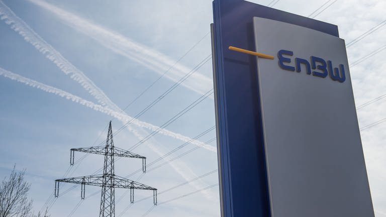 Das Logo des Energiekonzerns EnBW steht auf einem Schild vor der Firmenzentrale EnBW-City in Stuttgart. Im Hintergrund ist ein Strommast zu sehen. (Foto: dpa Bildfunk, Das Logo des Energiekonzerns EnBW steht auf einem Schild vor der Firmenzentrale EnBW-City in Stuttgart. Im Hintergrund ist ein Strommast zu sehen.)