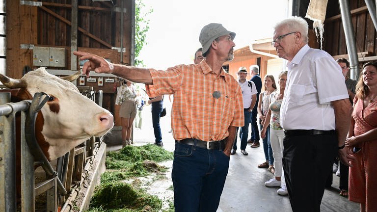 Winfried Kretschmann, Ministerpräsident von Baden-Württemberg, steht bei einem Besuch im Kuhstall des Bio Bauernhofes von Landwirt Friedhard Bühler (Foto: dpa Bildfunk, picture alliance/dpa | Bernd Weißbrod)