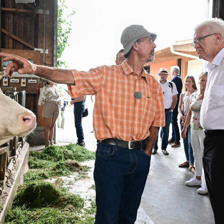 Winfried Kretschmann, Ministerpräsident von Baden-Württemberg, steht bei einem Besuch im Kuhstall des Bio Bauernhofes von Landwirt Friedhard Bühler (Foto: dpa Bildfunk, picture alliance/dpa | Bernd Weißbrod)