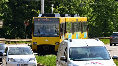 Gelbe U-Bahn fährt auf Straße in Stuttgart, im Vordergrund Autos. (Foto: dpa Bildfunk, picture alliance/dpa | Bernd Weißbrod)