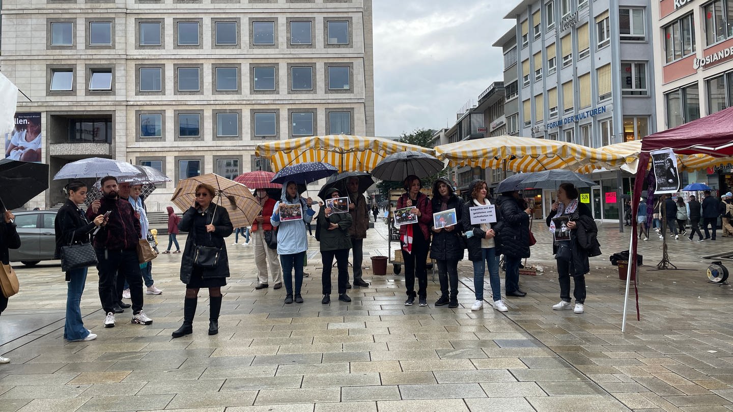 Auf dem Stuttgarter Markplatz demonstrieren im Regen Frauen und Männer für mehr Rechte von Frauen im Iran.
