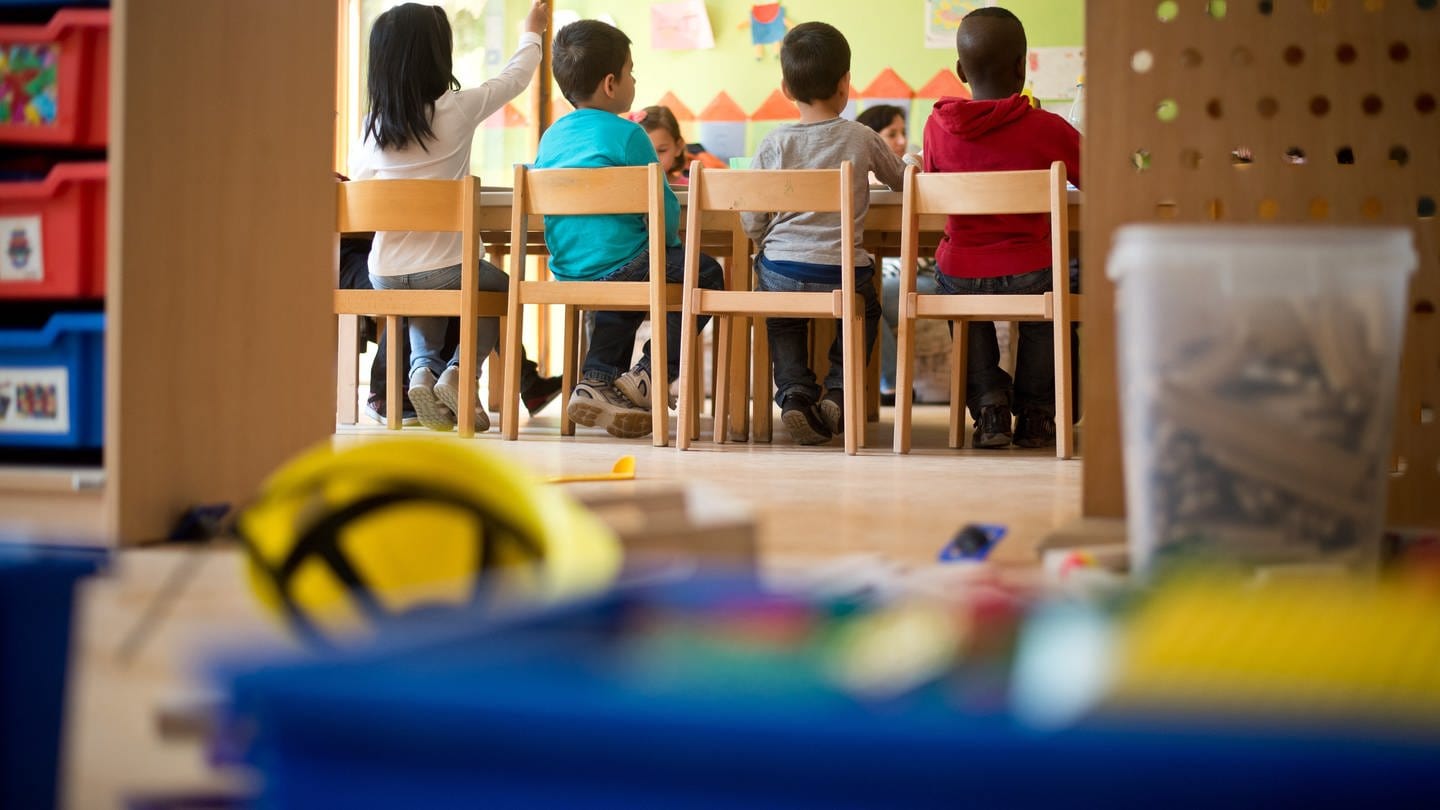 Kindergartenkinder sitzen an einem Tisch in Stuttgart (Baden-Württemberg) in einer Kindertagesstätte.