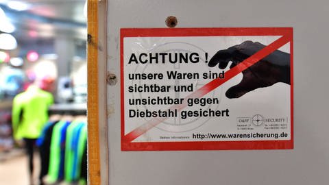 Ein Schild in einem Modegeschäft weist potenzielle Diebe auf Kameraüberwachung hin (Foto: dpa Bildfunk, picture alliance / dpa | Martin Schutt)
