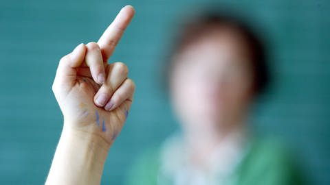 Schülerin zeigt Lehrerin den Mittelfinger. (Foto: IMAGO, IMAGO / photothek)