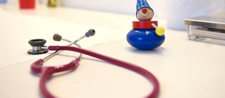 Ein Stethoskop und Kinderspielzeug liegen in einer Kinderarztpraxis. (Foto: dpa Bildfunk, picture alliance / dpa | Britta Pedersen)