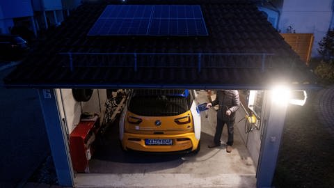 Ein Teilnehmer einer Projektstudie der Netze BW lädt in seiner Garage ein E-Auto. (Foto: dpa Bildfunk, picture alliance/dpa | Marijan Murat)