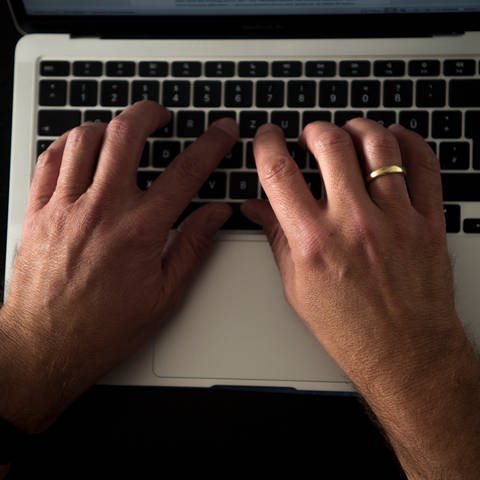 Ein Mann sitzt an einem Esstisch und arbeitet an einem Laptop. (Foto: dpa Bildfunk, picture alliance/dpa | Finn Winkler)