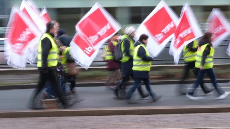 Teilnehmer einer Demonstration der Gewerkschaft Verdi laufen mit Fahnen der Gewerkschaft eine Straße entlang. (Foto: dpa Bildfunk, picture alliance/dpa | Sebastian Willnow)