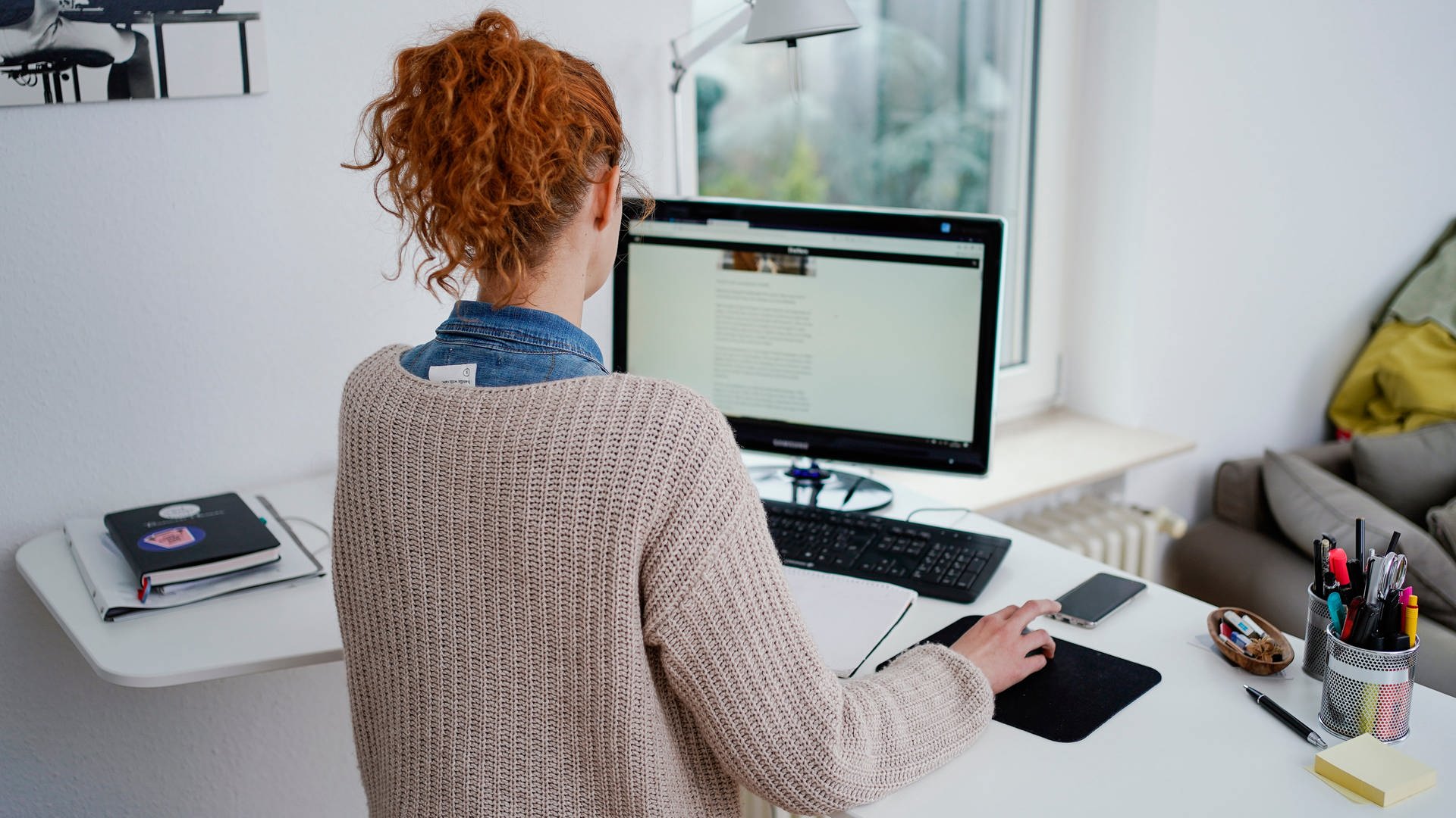 Eine Frau arbeitet in ihrer Wohnung vor einem Computer an einem Stehtisch. (Foto: dpa Bildfunk, picture alliance/dpa | Uwe Anspach)