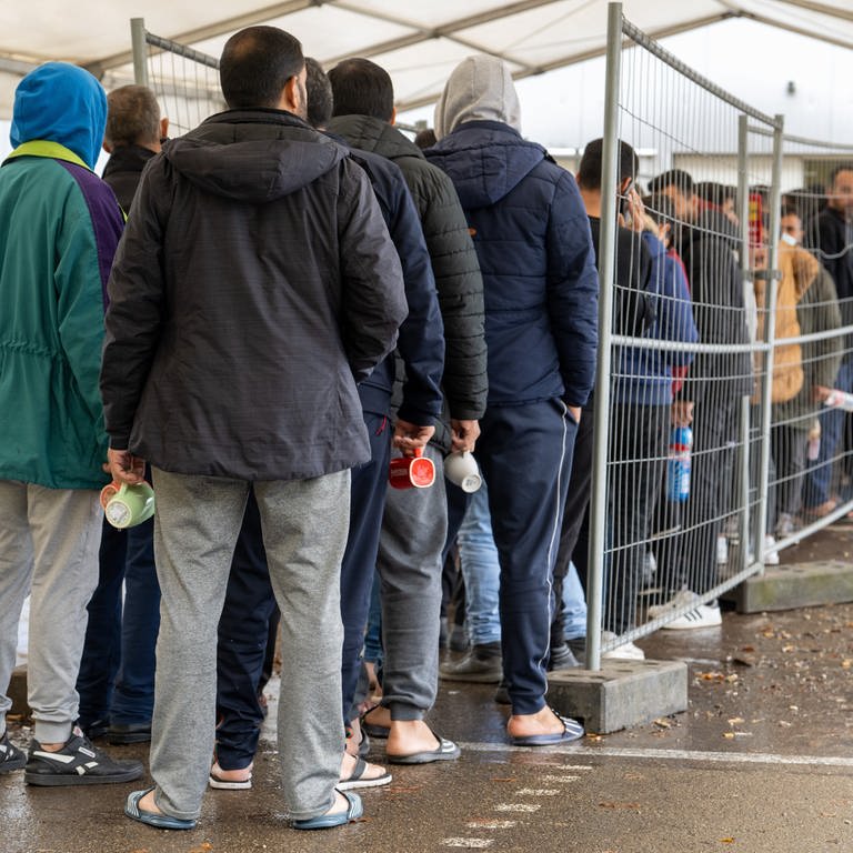 In der Landeserstaufnahmestelle (LEA) warten Flüchtlinge in einer Schlange vor der Essensausgabe.  (Foto: dpa Bildfunk, picture alliance/dpa | Stefan Puchner)