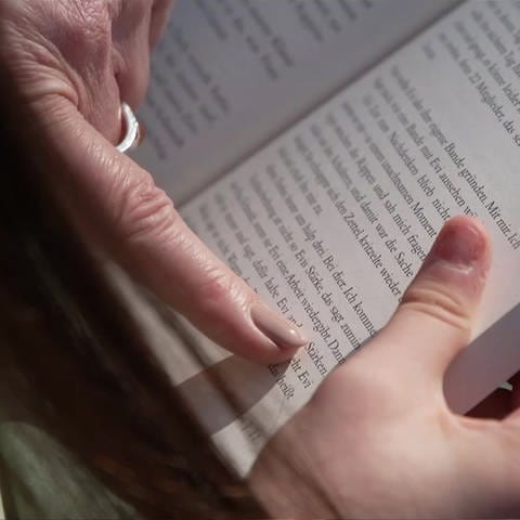 Finger zeigt auf ein Wort in einem Buch (Foto: SWR)