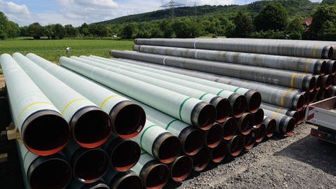 Rohre für eine Pipeline lagern auf einer Baustelle der Nordschwarzwaldleitung zwischen Au am Rhein und Leonberg neben einem Feld.  (Foto: Pressestelle, terranets BW)