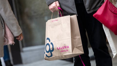 Ein Mann trägt eine Papiertasche mit dem Logo der Kaufhauskette Galeria Karstadt Kaufhof. (Foto: dpa Bildfunk, picture alliance/dpa | Thomas Banneyer)