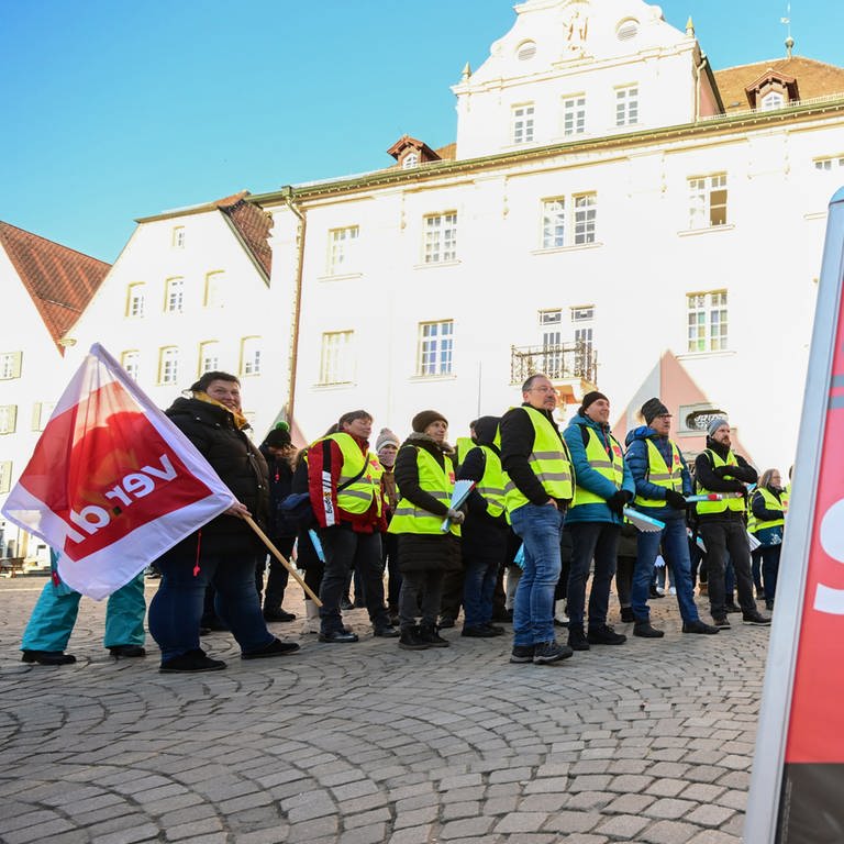 Mitglieder der der Gewerkschaft Verdi stehen bei einer Kundgebung mit Fahnen auf dem Marktplatz in Rottenburg. (Foto: dpa Bildfunk, picture alliance/dpa | Bernd Weißbrod)