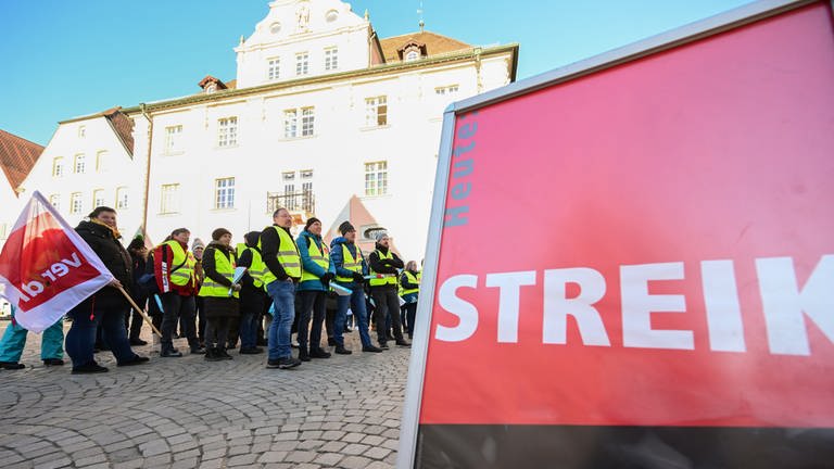 Mitglieder der der Gewerkschaft Verdi stehen bei einer Kundgebung mit Fahnen auf dem Marktplatz in Rottenburg. (Foto: dpa Bildfunk, picture alliance/dpa | Bernd Weißbrod)