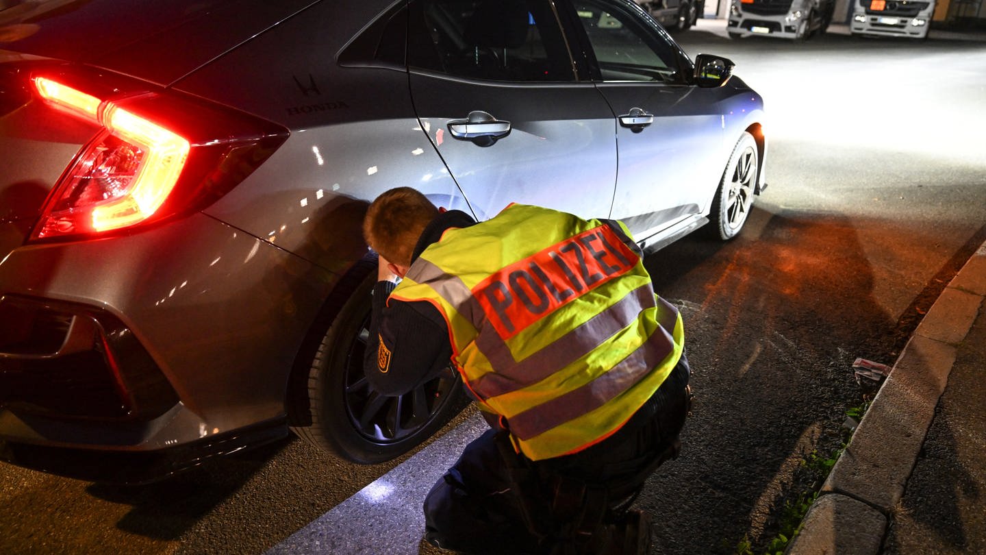 Ein Polizist kontrollieren ein Auto, das von einer Verkehrskontrolle am sogenannten Car-Freitag herausgezogen wurde. (Foto: dpa Bildfunk, picture alliance/dpa | Felix Kästle (Archivbild))