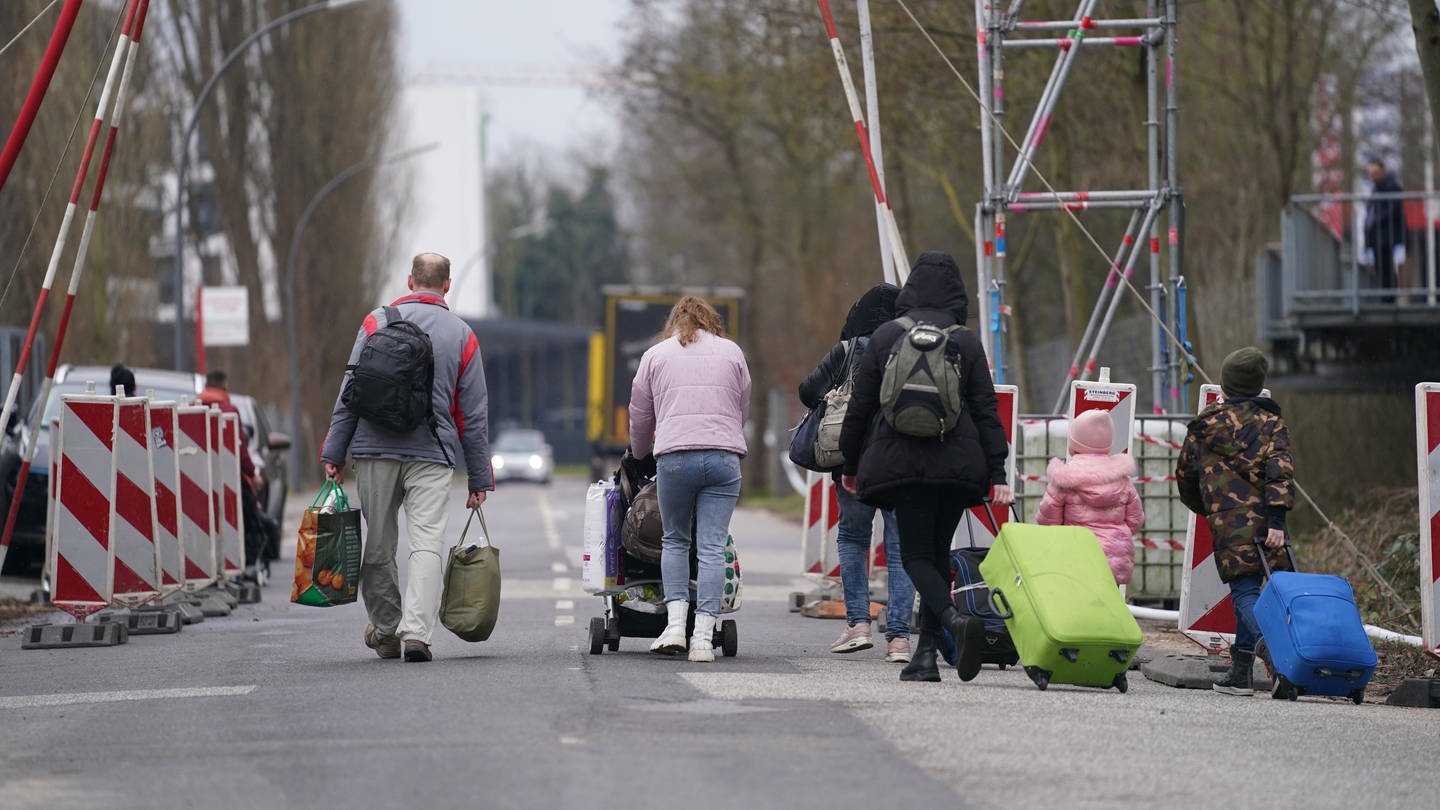 Ukrainische Flüchtlinge verlassen mit ihrem Gepäck die Flüchtlingsunterkunft im ehemaligen Fegro Großmarkt im Stadtteil Harburg. (Foto: dpa Bildfunk, picture alliance/dpa | Marcus Brandt)
