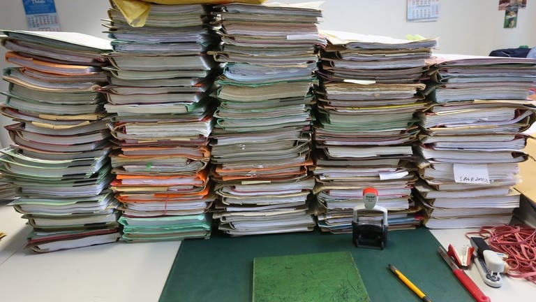 Stapel mit Akten liegen auf einem Schreibtisch. (Foto: dpa Bildfunk, picture alliance/dpa | Stephanie Pilick)