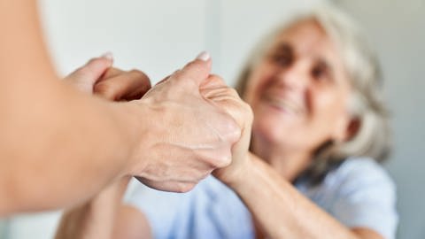 Die Hände einer Seniorin werden gehalten. (Foto: dpa Bildfunk, picture alliance / Zoonar | Robert Kneschke)