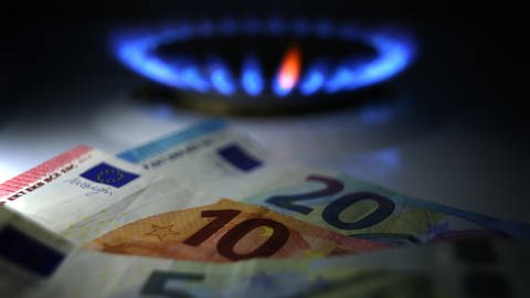 Gestelltes Bild zum Thema Gaspreise: Hinter Euro-Noten brennt an einem Herd eine Gasflamme.  (Foto: dpa Bildfunk, picture alliance/dpa | Karl-Josef Hildenbrand)