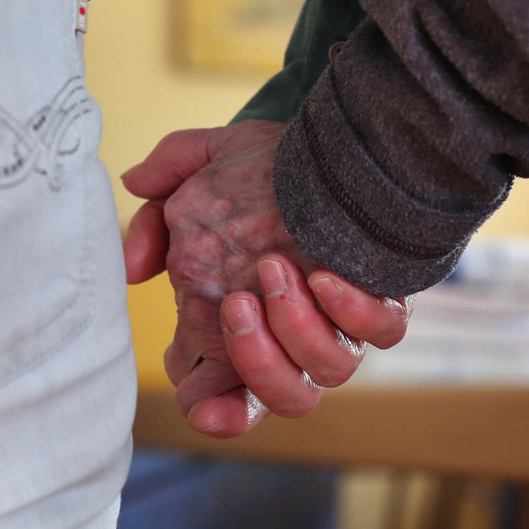 Eine Pflegekraft hält die Hand eines alten Menschen.  (Foto: dpa Bildfunk, picture alliance/dpa | Karl-Josef Hildenbrand (Symbolbild))