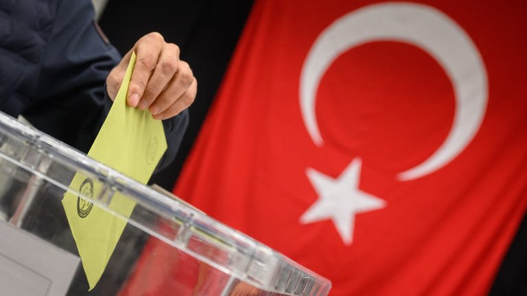 Ein Wähler wirft seinen Stimmzettel für die türkische Präsidentschaftswahl in eine Urne. (Foto: dpa Bildfunk, picture alliance/dpa | Julian Stratenschulte)