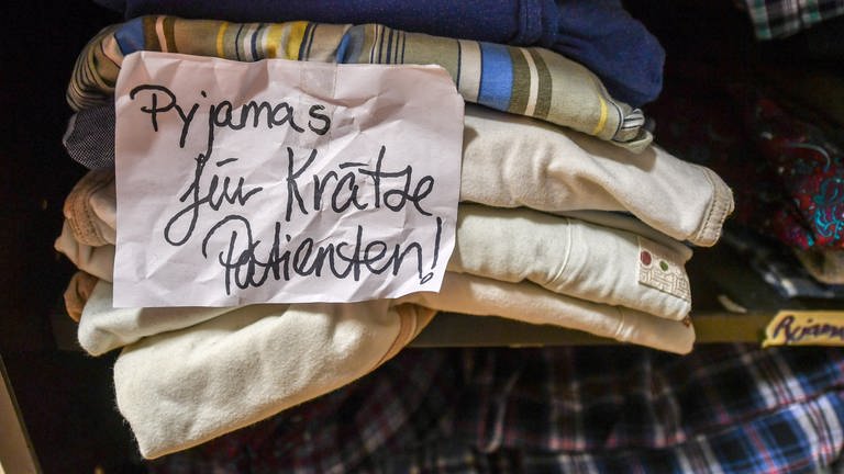In der Kleiderkammer einer Stadtmission liegen Pyjamas, die für Krätze-Patienten reserviert sind. (Foto: dpa Bildfunk, picture alliance/dpa/dpa-Zentralbild | Jens Kalaene (Symbolfoto))
