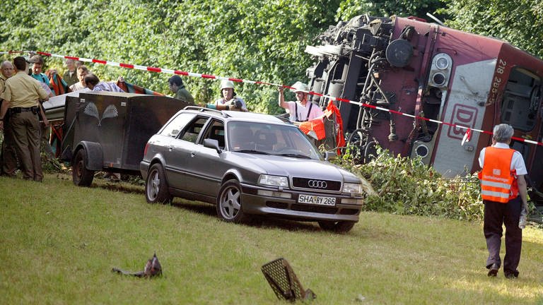 Ein Leichenwagen fährt am Mittwoch (1106.2003) an die entgleiste Lok. (Archiv) (Foto: dpa Bildfunk, picture-alliance / dpa/dpaweb | Harry_Melchert)