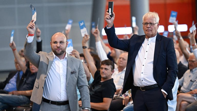 Die AfD Politiker Markus Frohnmaier (l) und Emil Sänze stehen in der Messehalle in Stuttgart beim AfD Landesparteitag gemeinsam im Saal. Sie werden zur neuen Doppelspitze im Land gewählt. (Foto: dpa Bildfunk, picture alliance/dpa | Bernd Weißbrod)