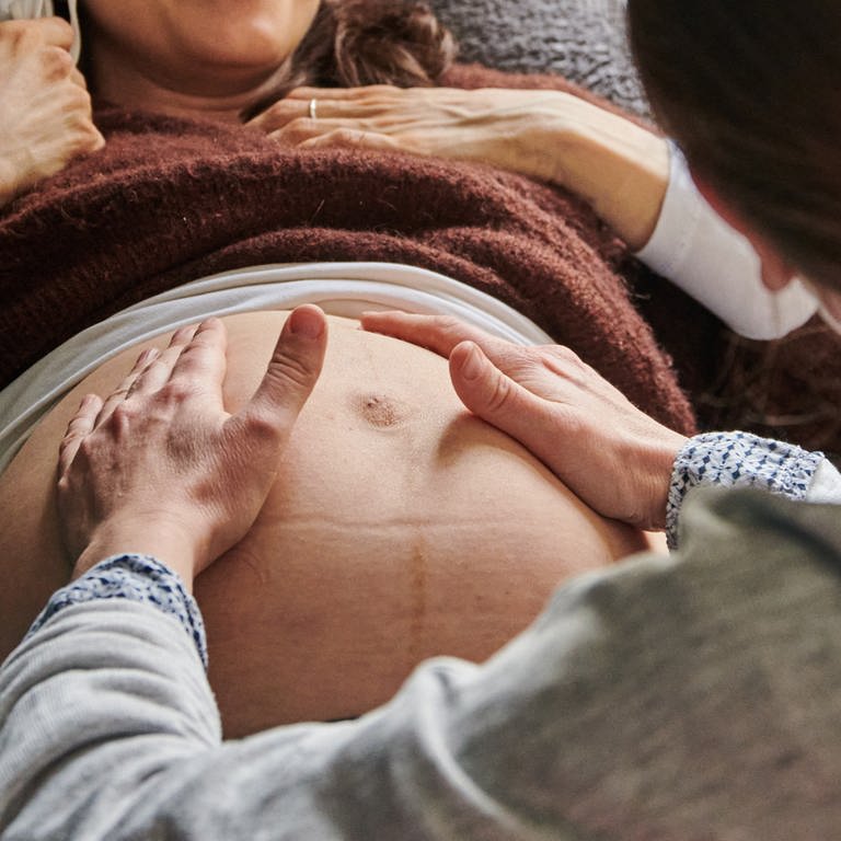 Eine Hebamme tastet in ihrer Praxis den Bauch einer schwangeren Frau ab.  (Foto: dpa Bildfunk, picture alliance/dpa | Annette Riedl)