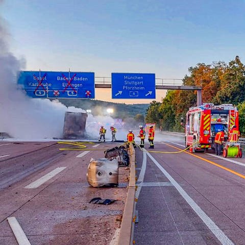 Unfall auf der A5 bei Karlsruhe: ausgebrannter Lkw liegt auf der Fahrbahn, Feuerwehrleute bei Löscharbeiten (Foto: ER24 / FW Ettlingen / EinsatzReport24)