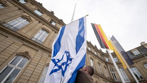 Die Flagge Israels wird von einem Mitarbeiter des Staatsministeriums Baden-Württemberg zwischen den Flaggen der EU, Deutschlands und Baden-Württembergs gehisst.  (Foto: dpa Bildfunk, picture alliance/dpa | Marijan Murat)