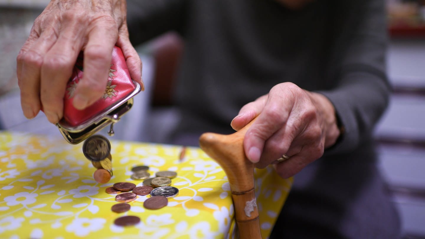 Eine Rentnerin schüttet Kleingeld aus einer Geldbörse auf den Küchentisch. (Foto: dpa Bildfunk, picture alliance/dpa | Felix Kästle)