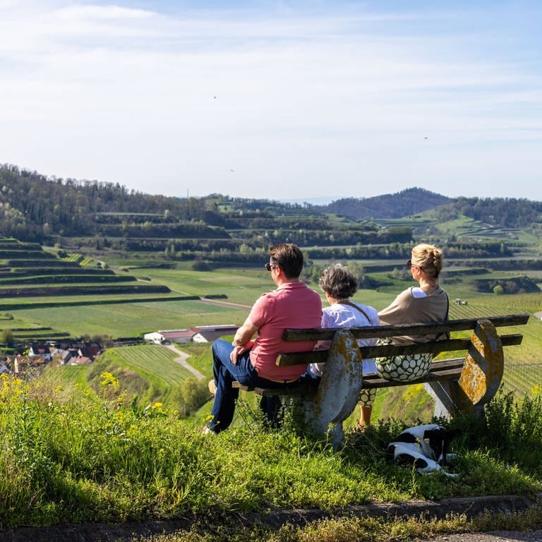 Drei Menschen sitzen auf einer Bank, mit Blick auf den Kaiserstuhl. (Foto: dpa Bildfunk, picture alliance/dpa | Philipp von Ditfurth)